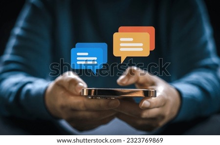 Human hand using smartphone typing Live chat chatting and social network concepts, chatting conversation working at home in chat box icons pop up. Social media marketing technology concept Royalty-Free Stock Photo #2323769869