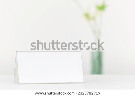 Blank white banner holder mock-up. Acrylic case, behind it a vase on a white background