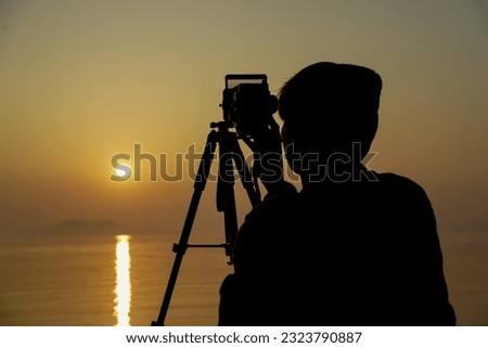 Asian man taking picture of sunrise 