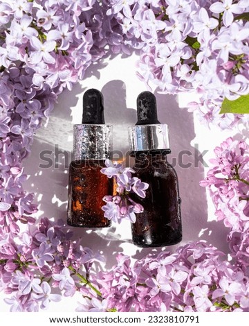 Lilac flowers aroma oil, flowers essential oil, pure essence. Essential Oils lilac. Spa oil with lilac flowers. Pipette with aroma oil and lilac flowers. Selective focus.