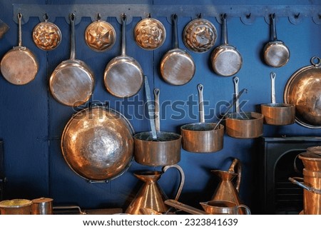Copper Pots and Pans and other Kitchen Utensils in an Antique Metal Kitchen. Royalty-Free Stock Photo #2323841639