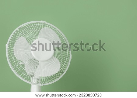 Modern electric fan on green background