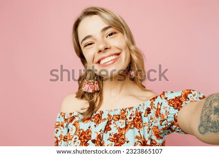 Close up smiling young blonde caucasian woman wear summer casual clothes doing selfie shot pov on mobile cell phone isolated on plain pastel light pink background studio portrait. Lifestyle concept