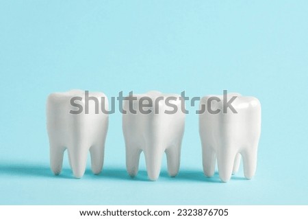 Three teeth in a row on a blue background. Dentistry clinic advertisement poster.