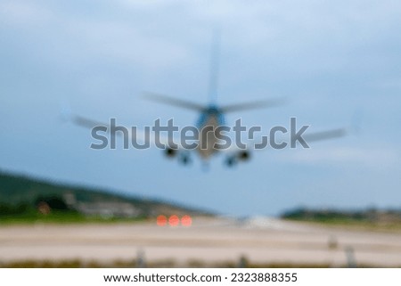 An airliner about to touch down onto a runway as seen from behind. Fully blurred picture ideal as a concept or background image. Copy space.