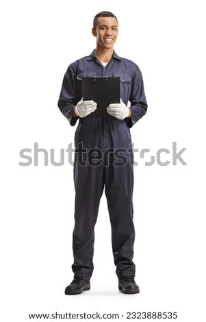 Full length portrait of an african american car mechanic holding a clipboard and smiling isolated on white background Royalty-Free Stock Photo #2323888535