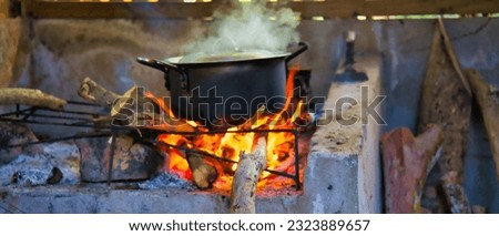 Authentic and traditional way of cooking the creole food in Seychelles, on  cast iron pot in direct wooden flames, Mahe Seychelles 1 Royalty-Free Stock Photo #2323889657