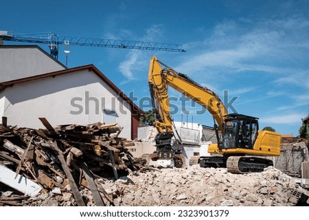 Excavator demolishing an old house for later construction on the site Royalty-Free Stock Photo #2323901379