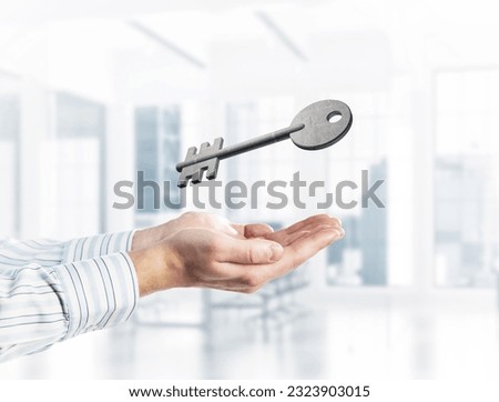 Cropped image of businessman in suit keeping stone key symbol in hands. Mixed media