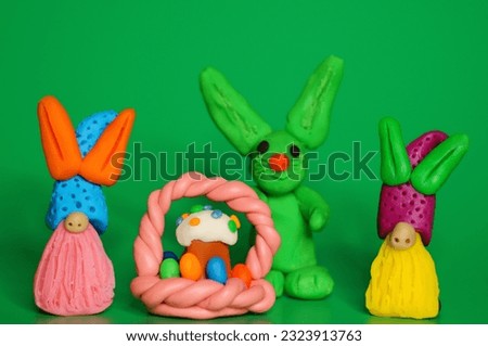 Toy Easter gnomes with a cake on a green background.