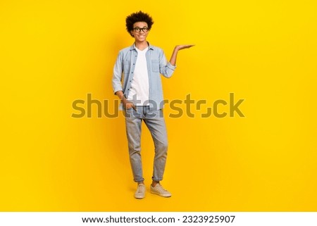 Full body photo of positive person hand palm hold demonstrate empty space isolated on yellow color background