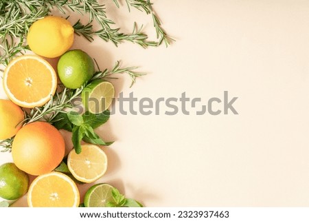Oranges, lemons, lime, rosemary and mint, citrus fruits on a beige background, palm leaf shadow. Summer party concept. Trendy palm leaf shadow and sunlight Royalty-Free Stock Photo #2323937463