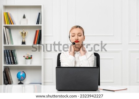 customer service cute blonde girl in office shirt with headset and computer holding neck