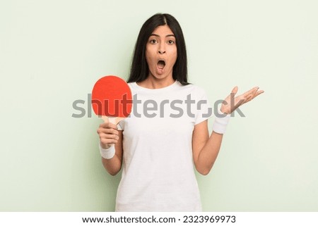 young pretty hispanic woman amazed, shocked and astonished with an unbelievable surprise. ping pong concept