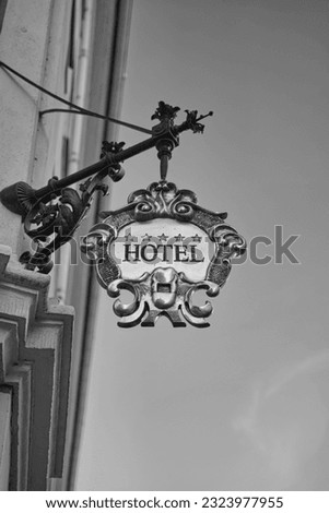 close up of three stars hotel sign in black and white