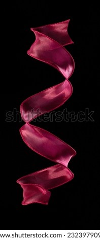 Red rose ribbon long straight fly in air with curve roll shiny. Red yellow ribbon for present gift birthday party to wrap around decorate, curl curve long straight. Black background isolated