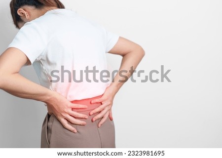 adult female with muscle pain on gray background. Elderly woman having back body ache due to Piriformis Syndrome, Low Back Pain and Spinal Compression. Office syndrome and medical concept Royalty-Free Stock Photo #2323981695