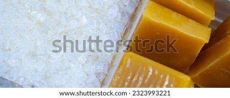 Hot melt adhesive in food labeling and packaging. Thermoplastic polymers. Non toxic hot melt glue block and hot melt adhesive pastilles or pellets. Chemical business industry. Packaging solutions. Royalty-Free Stock Photo #2323993221