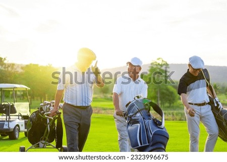 Group of Asian businessman and senior CEO holding golf bag walking on golf course with talking together. Healthy people enjoy outdoor sport lifestyle golfing at country club on summer holiday vacation Royalty-Free Stock Photo #2323996675