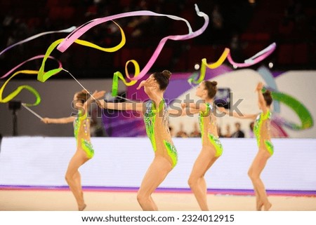 Young gymnasts dance with colored ribbons. Rhythmic gymnastics team competitions