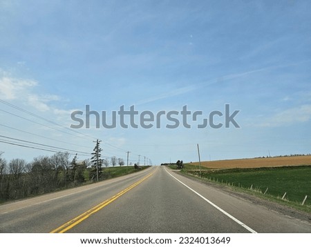 A wide open highway through a rural area of Prince Edward Island on a spring day.