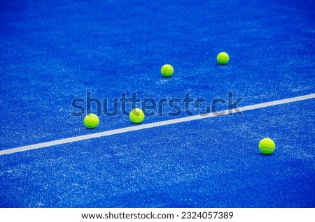 selective focus, several paddle tennis balls on a blue artificial grass paddle tennis court Royalty-Free Stock Photo #2324057389