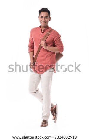 Full length portrait of a male in brown shirt ,with handbag standing isolated on white background