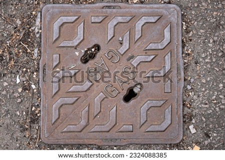 Cast Iron Gas Cover to Gas Utility Pipe in Pavement UK Royalty-Free Stock Photo #2324088385