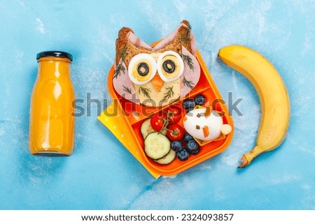 Funny owl sandwich with cheese and ham and egg in shape of rabbit. School lunch box for kids. Top view. Copy space
