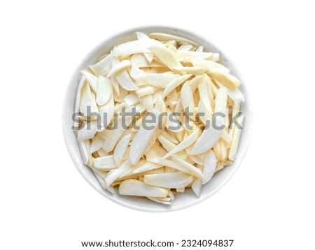 Sliced garlic isolated. Chopped garlic cloves. Heap of sliced garlic on white bowl with white background and selective focus