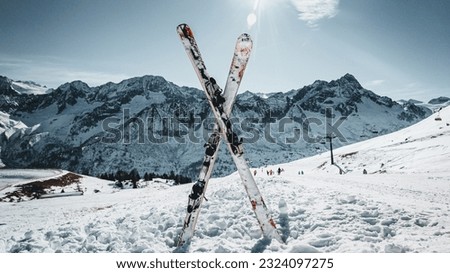 This striking image captures the essence of winter sports with a pair of skis forming a perfect X in fresh powder snow. Royalty-Free Stock Photo #2324097275