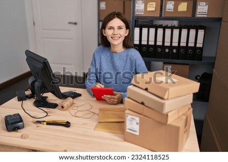 Young blonde woman ecommerce business worker writing on touchpad working at office