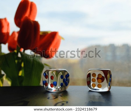 Transparent dice on the background of a window and a bouquet of red peonies Royalty-Free Stock Photo #2324118679
