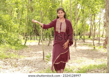 Close up of an Indian Odia teenage girl with long dark hairs wearing traditional dress salwar kameez. Royalty-Free Stock Photo #2324128997
