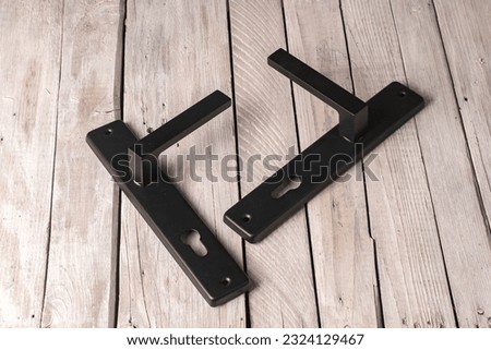 Metal black door knobs on a wooden table.