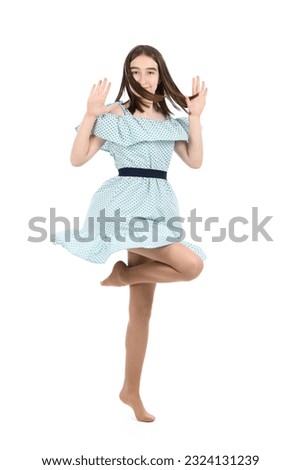 Young beautiful girl in a dress with polka dots on a white background. High resolution photo. Full depth of field.