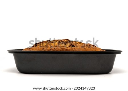 Freshly baked homemade chocolate banana bread in loaf pan. Isolated on white background with copy space. Side view. Royalty-Free Stock Photo #2324149323