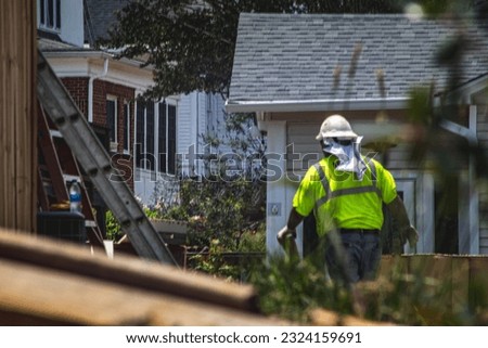 back of man in hardhat working with construction crew to remove debris after massive tornado in Georgia