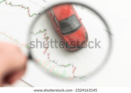 Toy car model and magnifying glass on white background