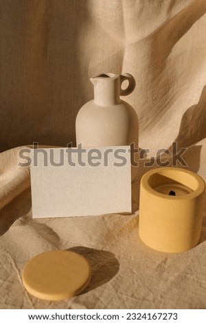 Blank paper mockup. Still life with empty card, ceramic vase, candle, linen. Showcase  of designs in an aesthetic setting.