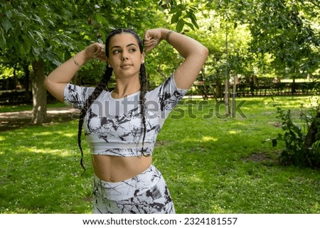 Inner strength in action: A beautiful athlete revealing her inner power through a gesture of strength, inspiring others to find their own strength and overcome themselves. Royalty-Free Stock Photo #2324181557