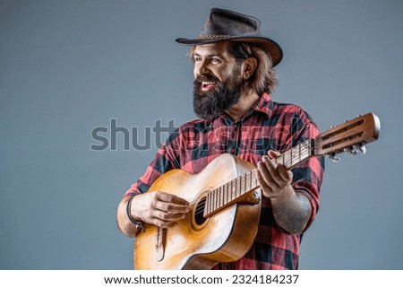 Cowboy playing guitar. Man cowboys playing acoustic guitars in wearing cowboy hat. Blues or country guitarist isolated on gray. Male in cowboys hat plays electric guitar. Old West Cowboy With Guitar.
