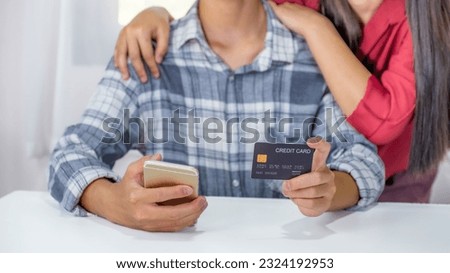 Young couple consumer hand holding mock up credit card, Ready to spend pay online shopping according to discount products via smartphone and laptop from home office.