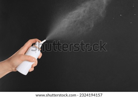 Woman spraying nasal medicine on black background, closeup. Space for text Royalty-Free Stock Photo #2324194157