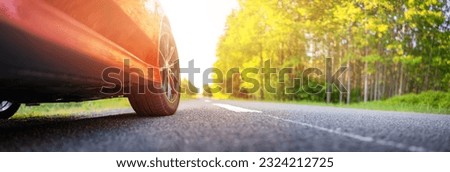 Red car on the country asphalt road in summer. Royalty-Free Stock Photo #2324212725