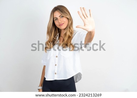 Young caucasian business woman wearing white shirt over white background showing and pointing up with fingers number five while smiling confident and happy. Royalty-Free Stock Photo #2324213269