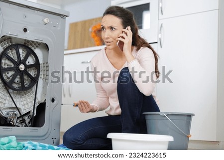 woman is calling a plumber to repair the leak Royalty-Free Stock Photo #2324223615
