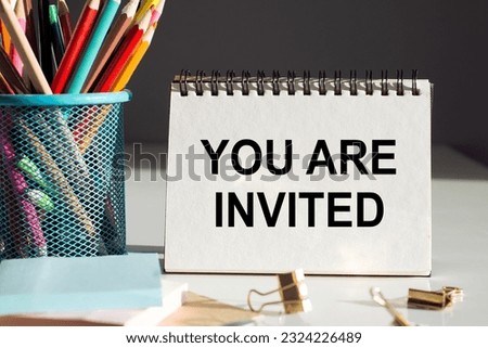 ARE YOU INVITED text on notepad with office tools