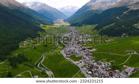 Aerial view of Livigno village in Valtellina, Lombardia, Italy. Drone panoramic view of the lake and valley. Mountain road, forest and alpine lake: Lago del Gallo. Birds Eye Italy, province of Sondrio