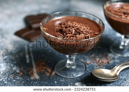 Chocolate mousse with nuts in a glasses on a slate, stone or concrete table. Royalty-Free Stock Photo #2324238751